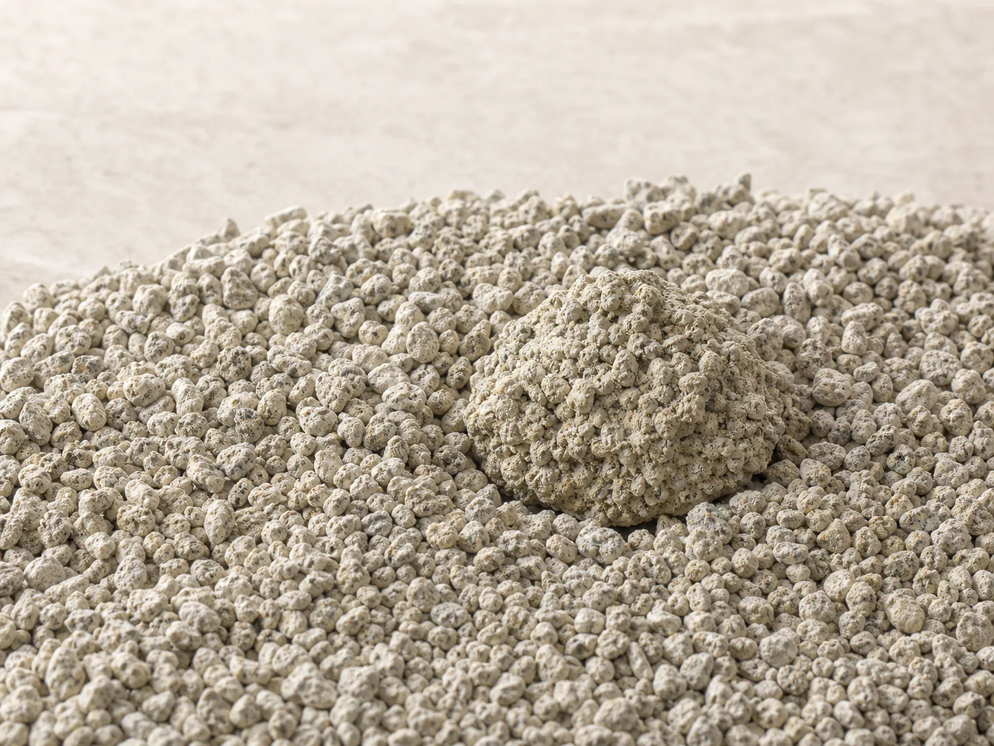 Close view of natural bentonite cat litter granules with a formed clump