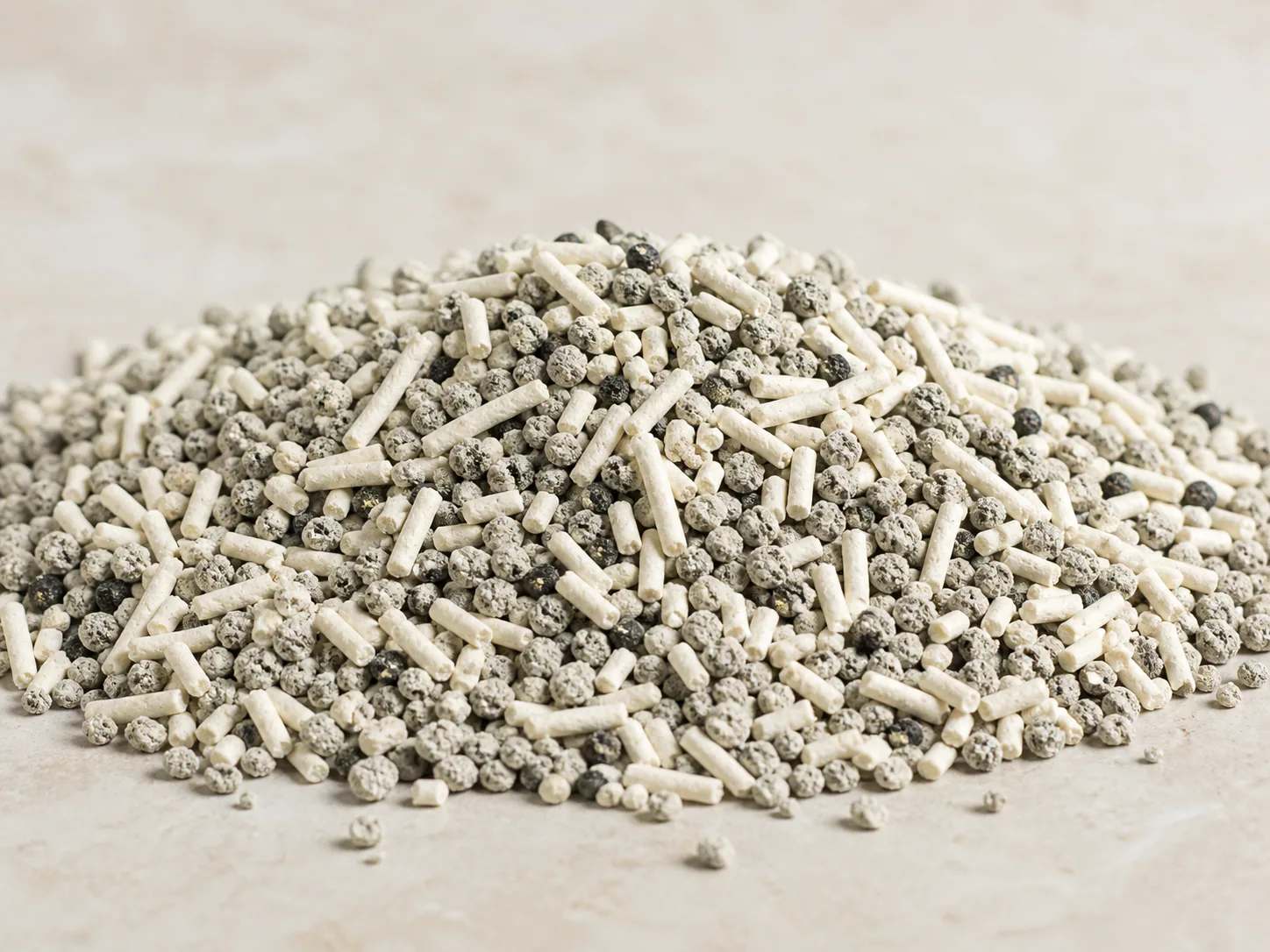 Close view of a mixed cat litter formula containing plant fiber pellets and mineral granules
